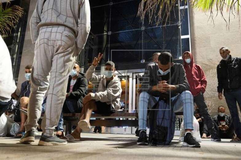 Inmigrantes trasladados desde Las Palmas de Gran Canaria esperan en Santa Cruz de Tenerife para embarcar hacia Huelva (EFE / Miguel Barreto)